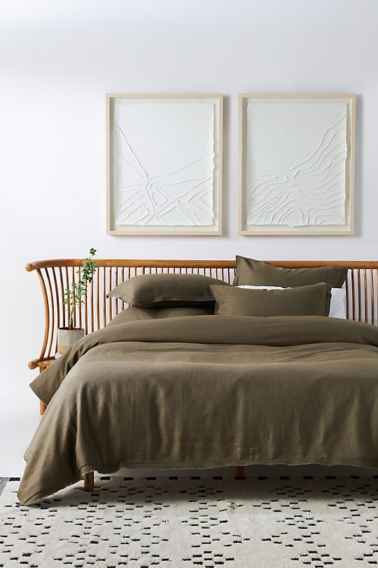 olive green bedding, wood headboard, white art, minimalist neutral art, unique bed