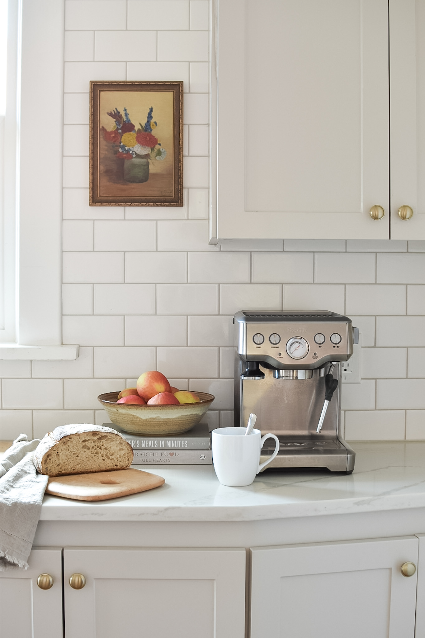 Kitchen cabinets DIY Painted with Benjamin Moore Revere Pewter. Marble-look quartz counters and white backsplash tile