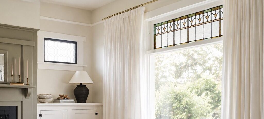 Inexpensive curtain panels styled to look like custom pinch-pleat drapes